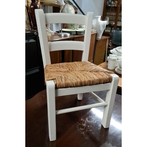 446 - Child-sized wooden chair with a white-painted finish and woven natural fiber seat.