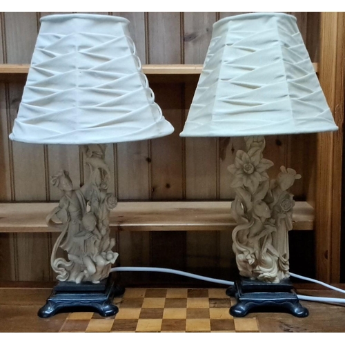 451 - Pair of table lamps with intricate carved resin bases featuring floral and figure motifs, topped wit... 