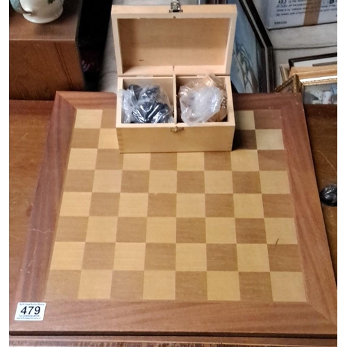 479 - Wooden chess board with inset squares. Includes a complementary storage box containing chess pieces,... 