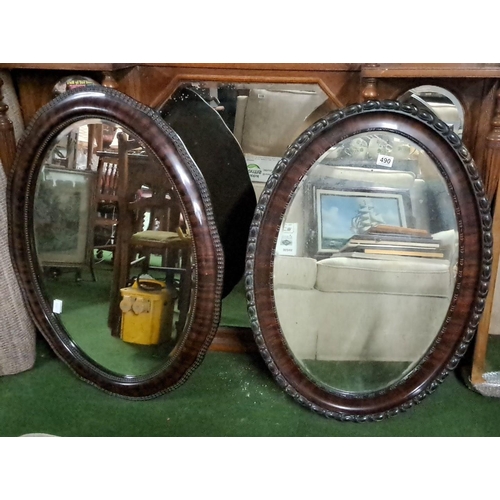 490 - Pair of antique oval mirrors with wooden frames. The product features intricate carved details. Like... 