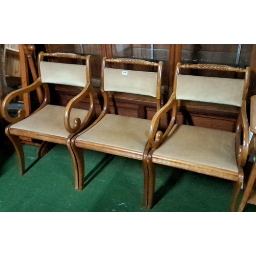 498 - Set of three oak dining chairs with curved armrests and upholstered seats and backrests, featuring i... 