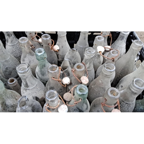 524 - Collection of 26 antique glass bottles with wire bale tops, featuring vintage designs and varying te... 