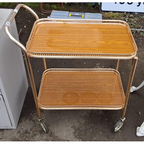 540 - Mid-Century Modern two-tier serving trolley. It has wood-laminate shelves and a gold-tone metal fram... 