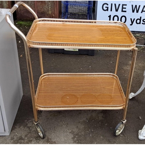 540 - Mid-Century Modern two-tier serving trolley. It has wood-laminate shelves and a gold-tone metal fram... 