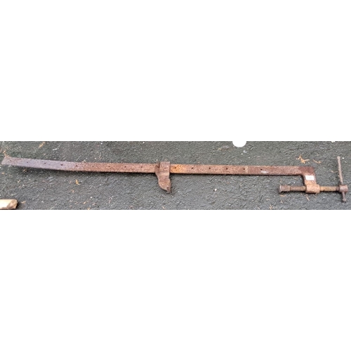 546 - Vintage iron carpenter’s clamp, approximately 50 inches, with a screw mechanism for adjustable grip.... 