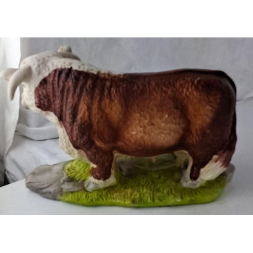 24 - A hand-painted ceramic figurine representing a cow and calf on grass. It comes with a lifelike fur t... 