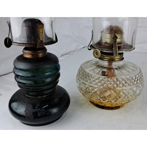 51 - A pair of vintage glass kerosene lamps are presented. One features a ribbed dark glass base, measuri... 