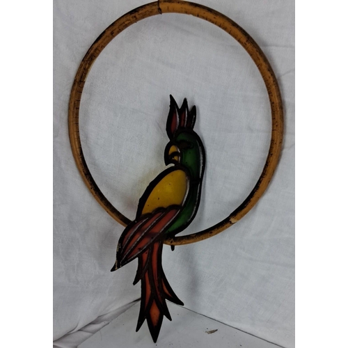 65 - Stained glass parrot in a bamboo ring, with vibrant colors of green, yellow, and red.