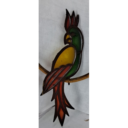 65 - Stained glass parrot in a bamboo ring, with vibrant colors of green, yellow, and red.