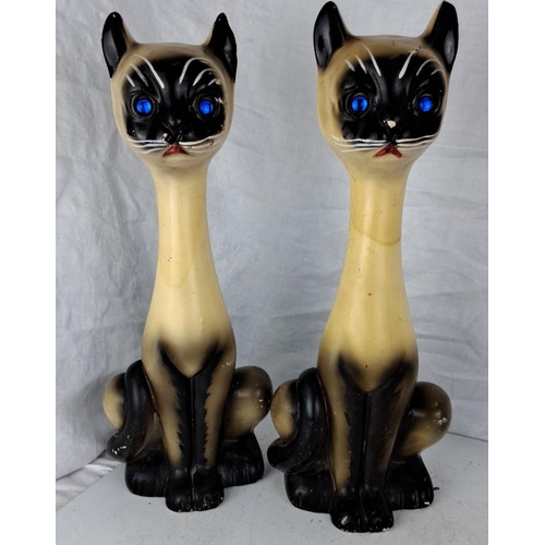 78 - Pair of vintage ceramic Siamese cat figurines with blue glass eyes. They feature hand-painted detail... 