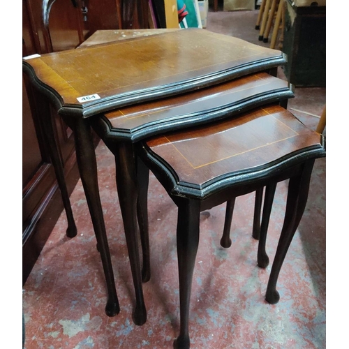 464 - Set of three nested mahogany tables, featuring scalloped edges and elegant curved legs. From the mid... 