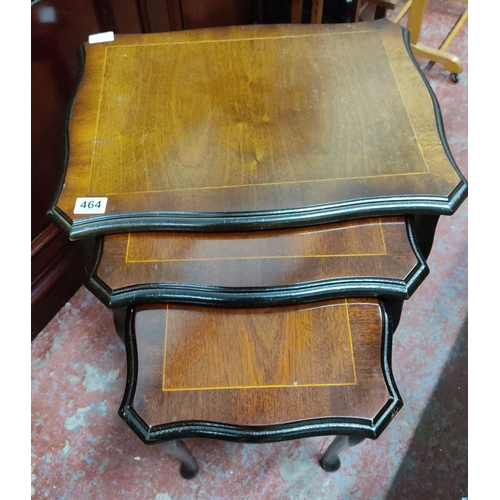 464 - Set of three nested mahogany tables, featuring scalloped edges and elegant curved legs. From the mid... 