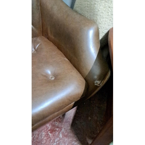 492 - Mid-Century Modern brown faux-leather lounge chair features tufted detailing and wooden armrests. It... 