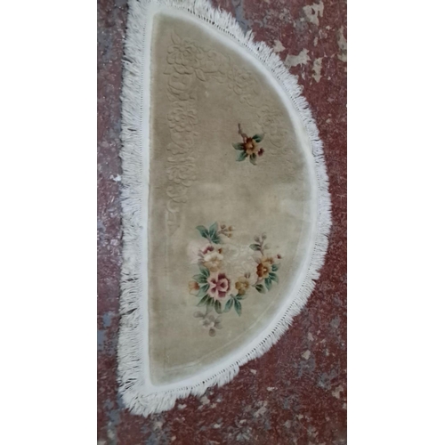 495 - Semi-circular rug with floral embroidery and fringed edges. It has delicate flower motifs on a beige... 