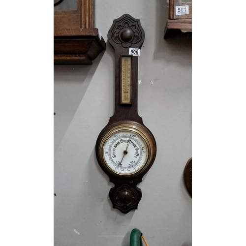 500 - Antique wall barometer and thermometer, made in England. Made from dark wood with decorative element... 