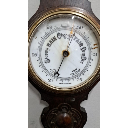 500 - Antique wall barometer and thermometer, made in England. Made from dark wood with decorative element... 