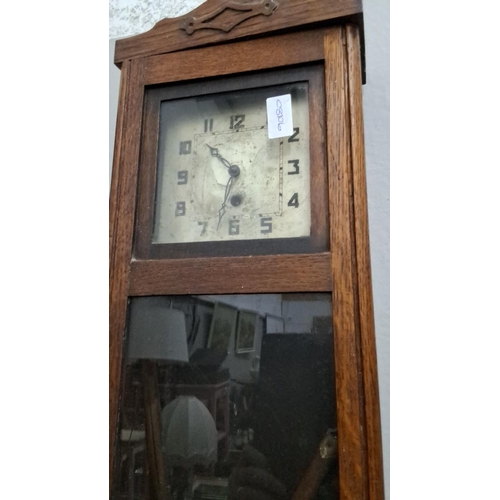 501 - Early 20th-century wall clock housed in a solid oak case with a glass panel. It features a brass pen... 