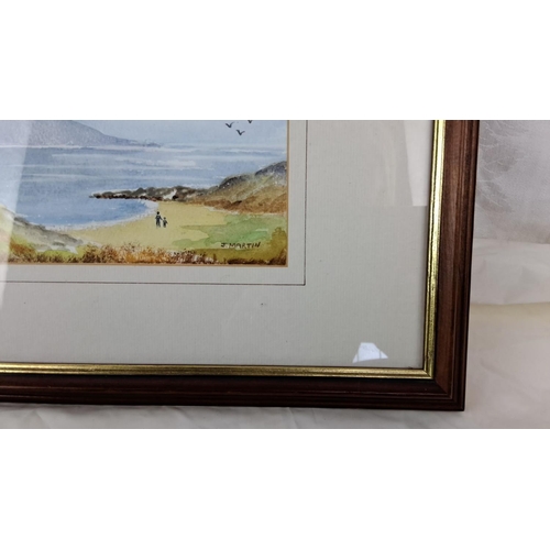 14 - A watercolour painting by J. Martin, illustrating a tranquil coastal landscape with framed beachgoer... 