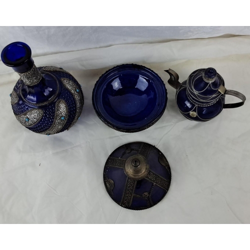 33 - A set of three cobalt blue glass pieces, each exhibiting intricate designs with ornate silver embell... 