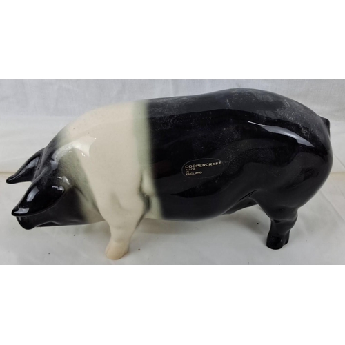 61 - A Coopercraft ceramic figure of a pig, hailing from England. It features a black and white glaze.