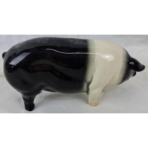 61 - A Coopercraft ceramic figure of a pig, hailing from England. It features a black and white glaze.