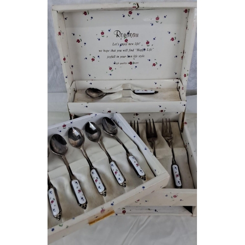 7 - A boxed set of six forks and seven spoons with delicate floral enamel handles.