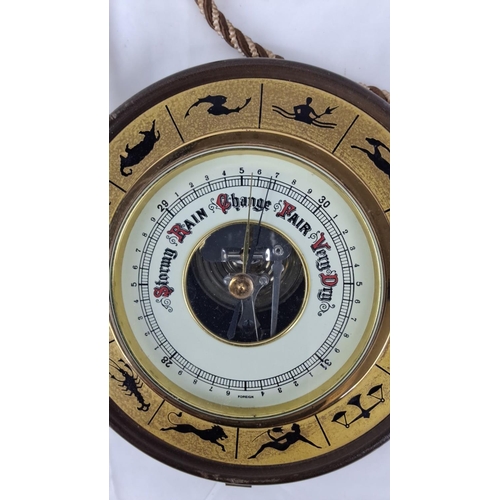 82 - A vintage hanging barometer made of brass and features zodiac symbols. It measures atmospheric press... 