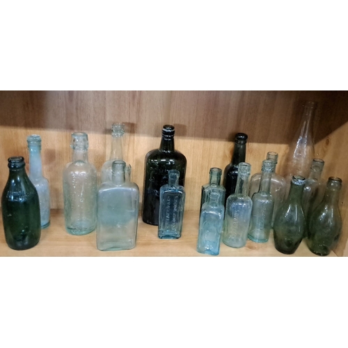 102 - Assortment of 17 vintage glass bottles. The collection includes clear, green, and aqua-colored bottl... 