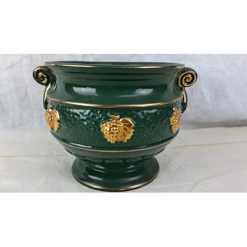 114 - Green ceramic jardinière with gold grapevine accents and decorative scroll handles. It features a te... 