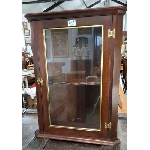 637 - This is a mahogany corner cabinet with brass hinges and a glass door. The cabinet is labeled 