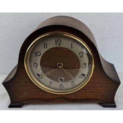 644 - Antique wooden mantel clock with brass movement has an elegant arched design. The clock face feature... 