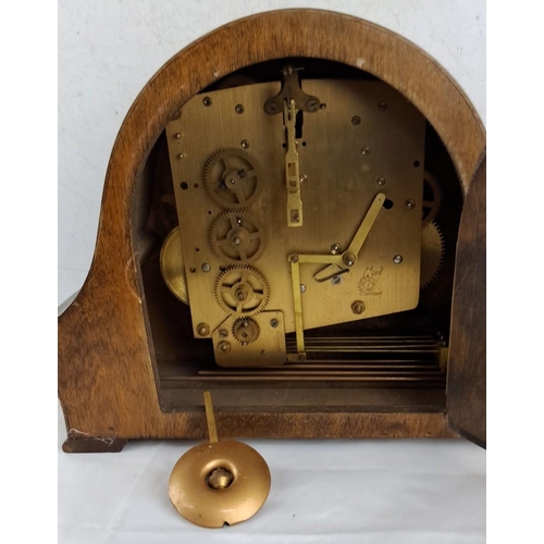 644 - Antique wooden mantel clock with brass movement has an elegant arched design. The clock face feature... 