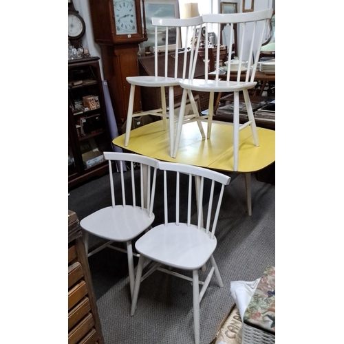 651 - A set of four white wooden spindle-back dining chairs in a Mid-Century Modern style.