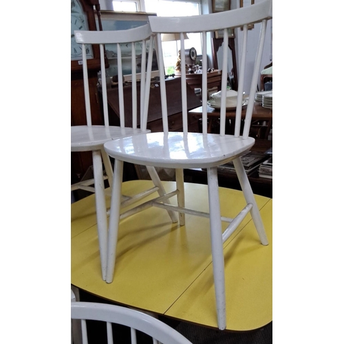 651 - A set of four white wooden spindle-back dining chairs in a Mid-Century Modern style.