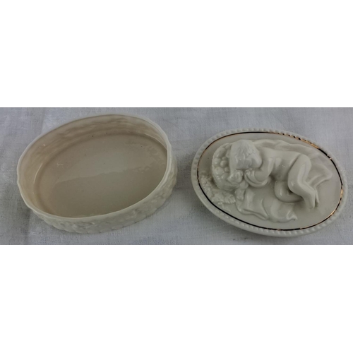 18 - Unusual Belleek trinket box adorned with a cherub and floral design, featuring delicate gilt accents... 