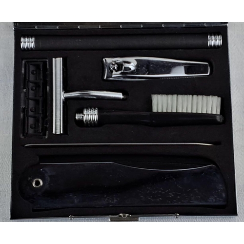 20 - Metallic case containing nail clippers, razor, brush, and related grooming tools with a logo on the ... 