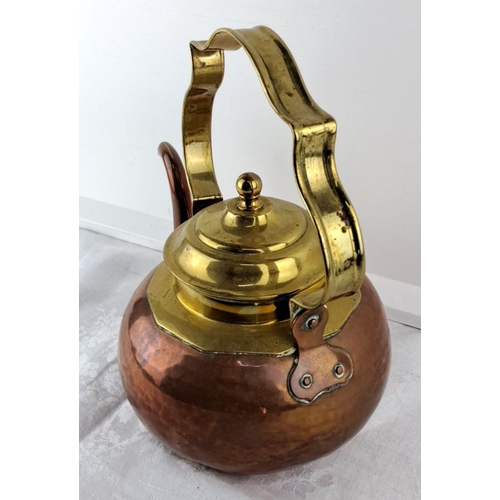 68 - Vintage copper and brass kettle with a hammered texture and ornate handle.