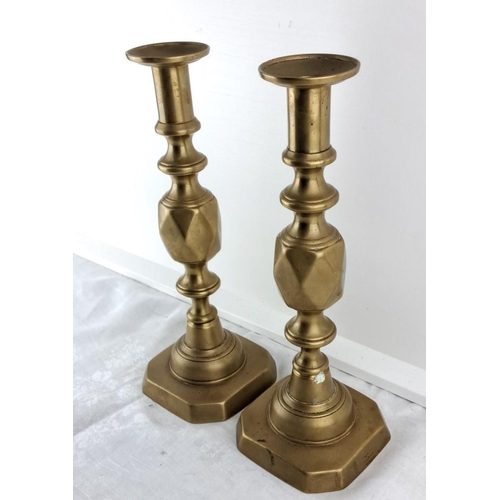 69 - Pair of brass candlesticks with octagonal bases, featuring turned column designs, from the Victorian... 