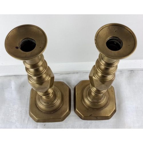 69 - Pair of brass candlesticks with octagonal bases, featuring turned column designs, from the Victorian... 