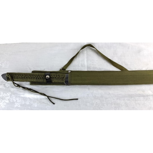 73 - Military-style sword with green woven fabric handle and scabbard, featuring decorative knotting on t... 