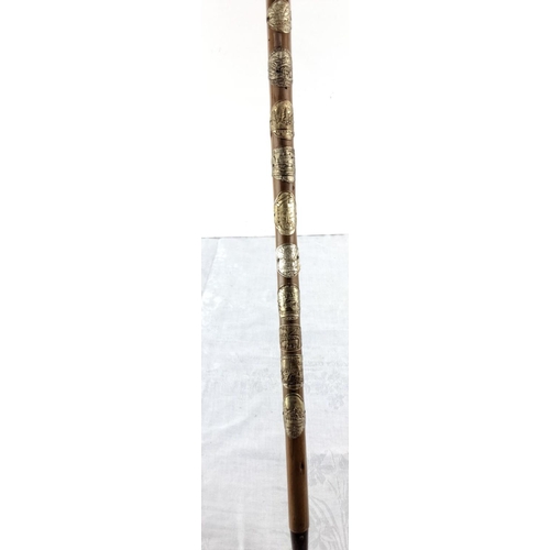 77 - Vintage walking stick adorned with multiple badges from various regions, featuring detailed engravin... 