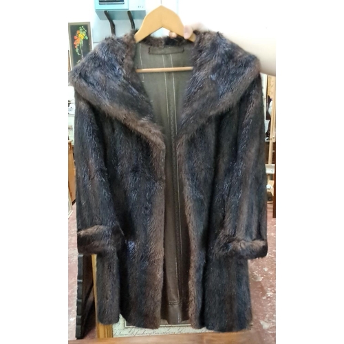 584 - Vintage dark brown fur coat features a wide collar and lapels, long sleeves, and a full-length desig... 