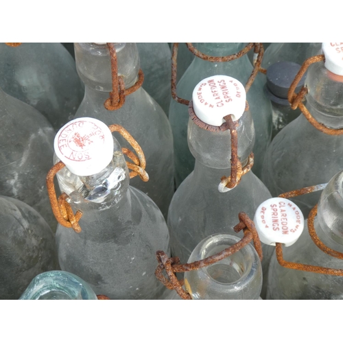 11 - A large collection of vintage glass bottles to include Madden Claredon Springs, Derry.