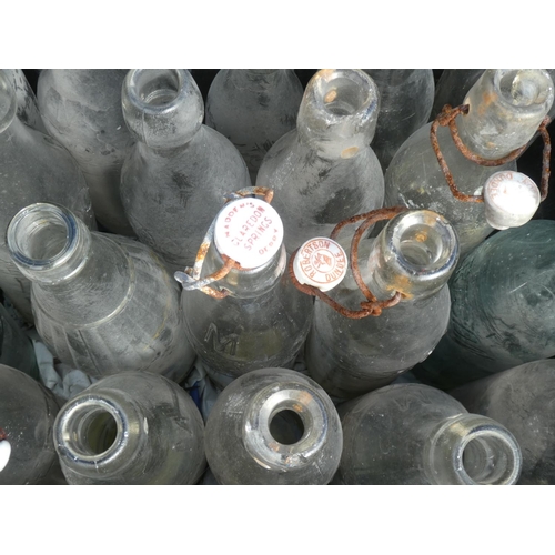 24 - A large collection of vintage glass bottles to include Madden Claredon Springs, Derry.