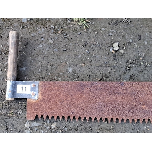 11 - Vintage two-man crosscut saw with wooden handles and a long, rusted metal blade featuring large teet... 