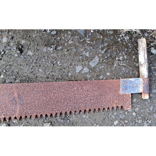 11 - Vintage two-man crosscut saw with wooden handles and a long, rusted metal blade featuring large teet... 