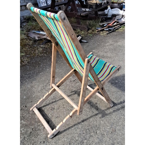 12 - Vintage wooden deck chair with vibrant, multicolored striped canvas seat. Folds for easy storage.