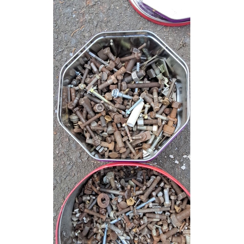 40 - Two metal tins contain mixed bolts, nuts, and assorted hardware items in various sizes and condition... 