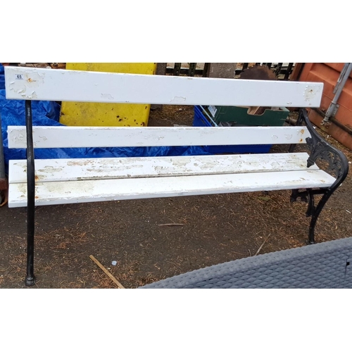 66 - outdoor bench with cast iron floral-patterned sides and white-painted wooden slats.