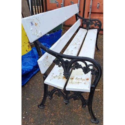 66 - outdoor bench with cast iron floral-patterned sides and white-painted wooden slats.